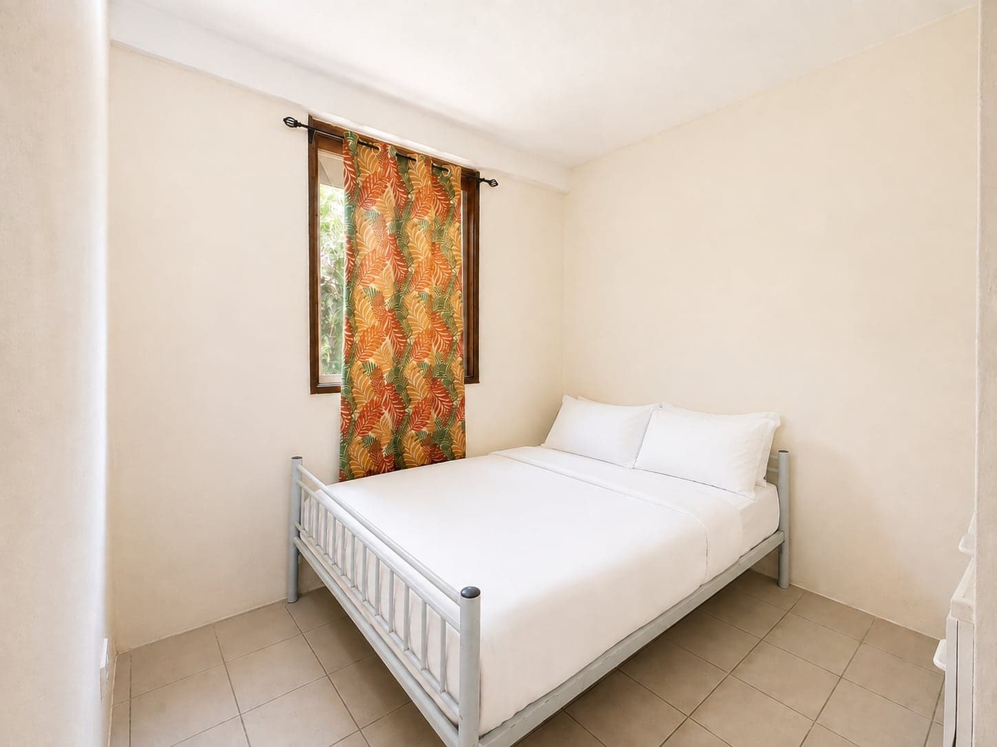 A bedroom in the apartment, with a window on the forest